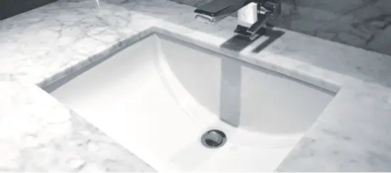 Modern white rectangular undermount bathroom sink on marble countertop