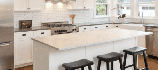 Modern white kitchen with island, subway tile backsplash and black bar stools