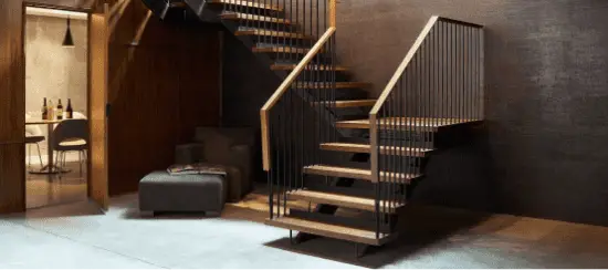 Modern floating wooden staircase with black metal railings in luxury home interior
