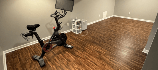 Modern home gym with exercise bike on wood floors in empty room