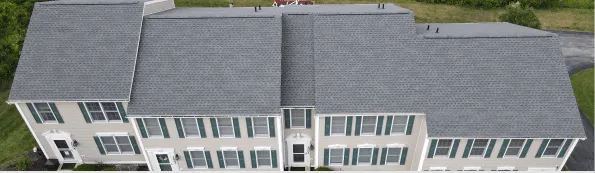 Aerial view of white townhouse complex with gray roofs and green shutters