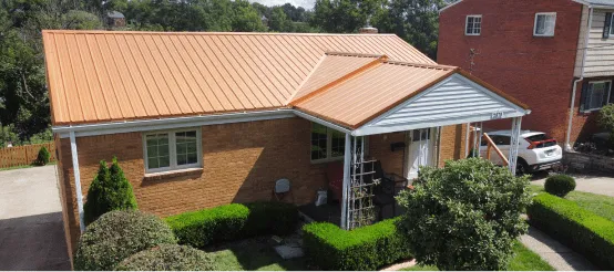 Brick house with copper metal roof and white trim in residential neighborhood