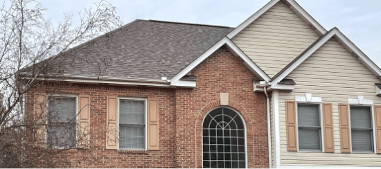 Modern two-story brick and vinyl siding house with arched front door entrance