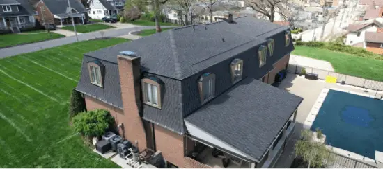Aerial view of modern two-story house with gray shingle roof and swimming pool