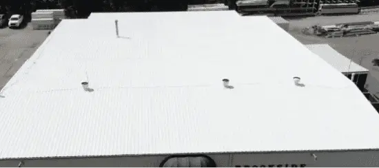 White commercial flat roof with membrane roofing system and ventilation units