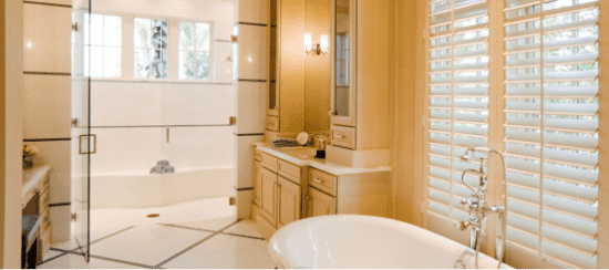 Modern luxury bathroom with glass shower, soaking tub and plantation shutters