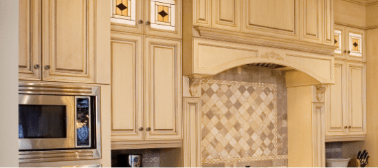 Elegant cream kitchen cabinets with decorative tile backsplash and built-in microwave