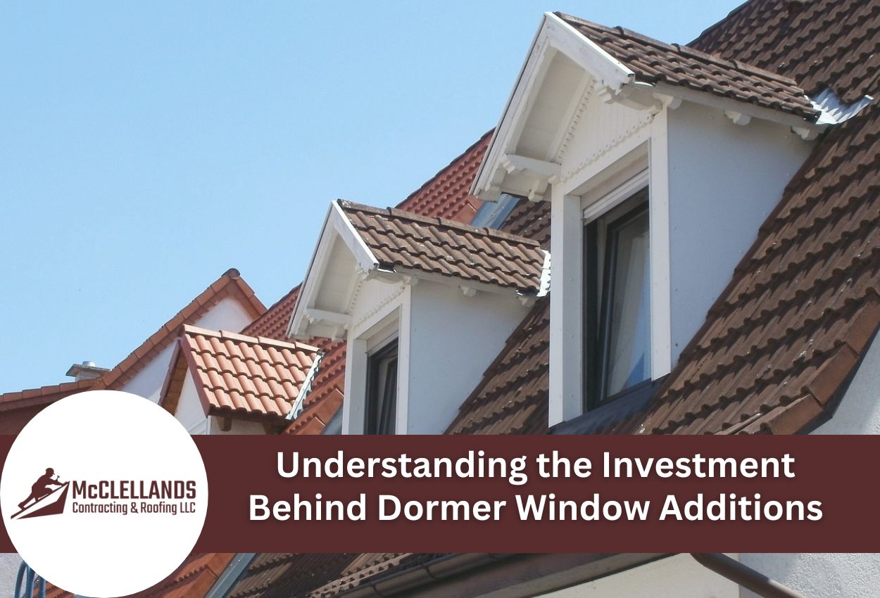 Dormer windows on clay tile roof with white trim against blue sky
