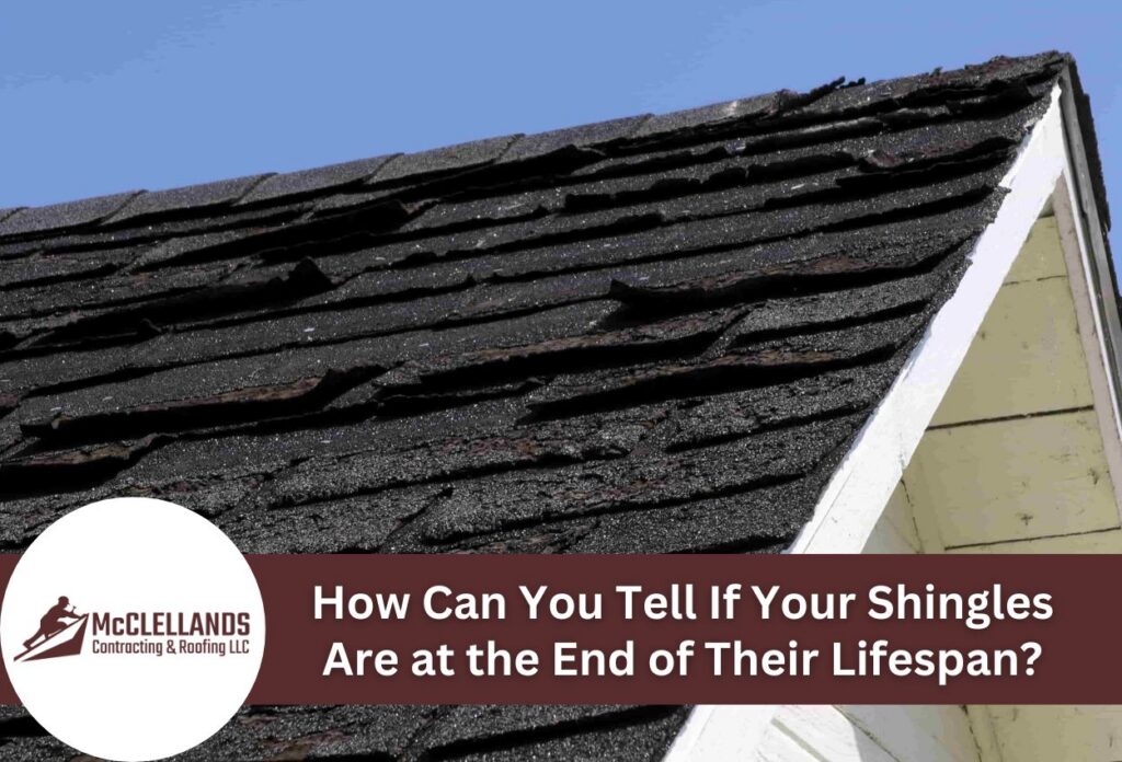 Aging roof shingles with visible damage under a clear blue sky.