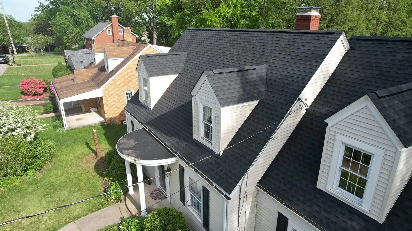 Aerial view of suburban houses with well-maintained roofs and gardens