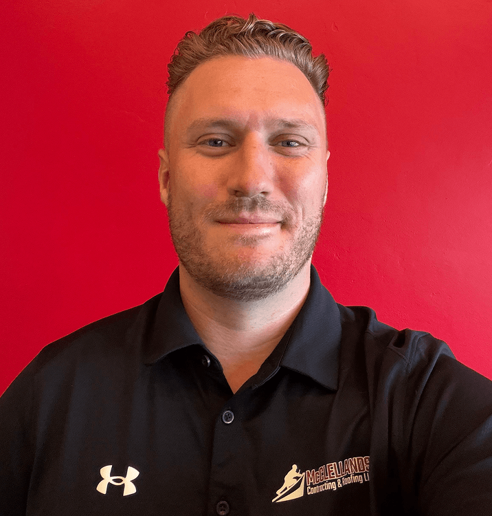 Man in black shirt with logo against red wall background