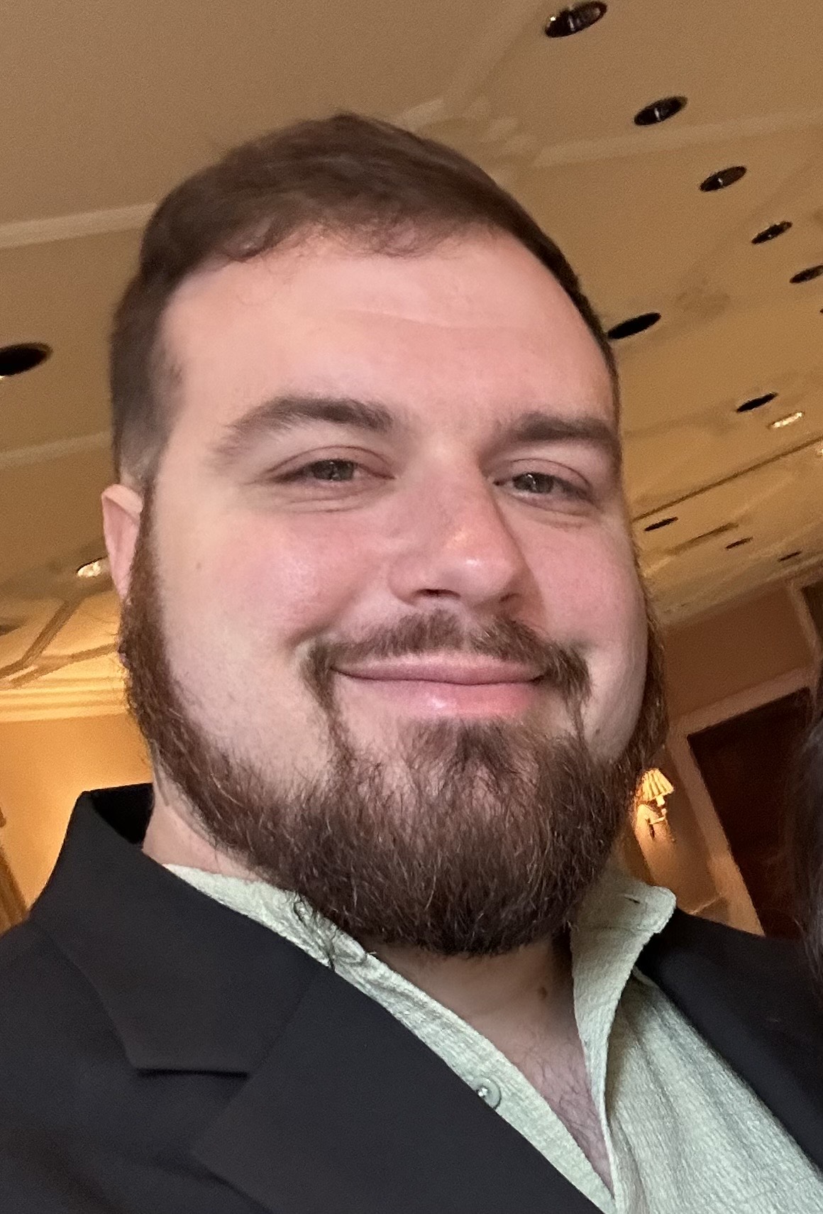 Portrait of a smiling man with a beard at a formal event