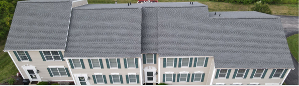 Aerial view of a large two-story beige building with gray roofing