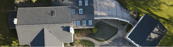 Aerial view of modern house with skylights and surrounding driveway