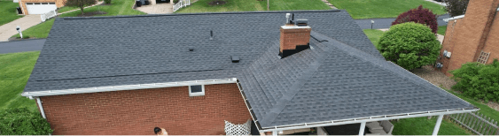 Aerial view of a residential house with a new black shingled roof.